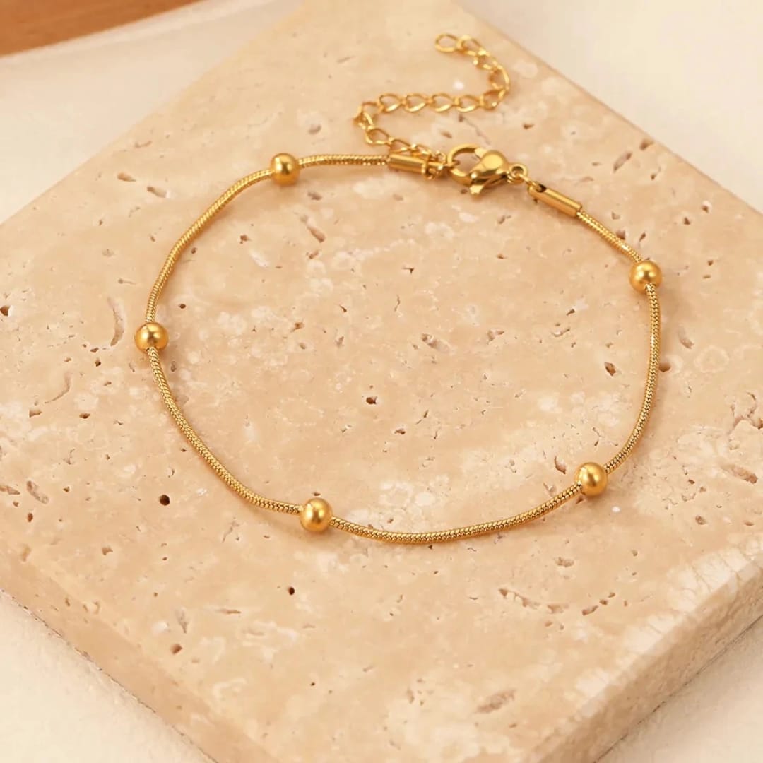 Bracciale Sottile con Sfere Dorate in Acciaio Inox