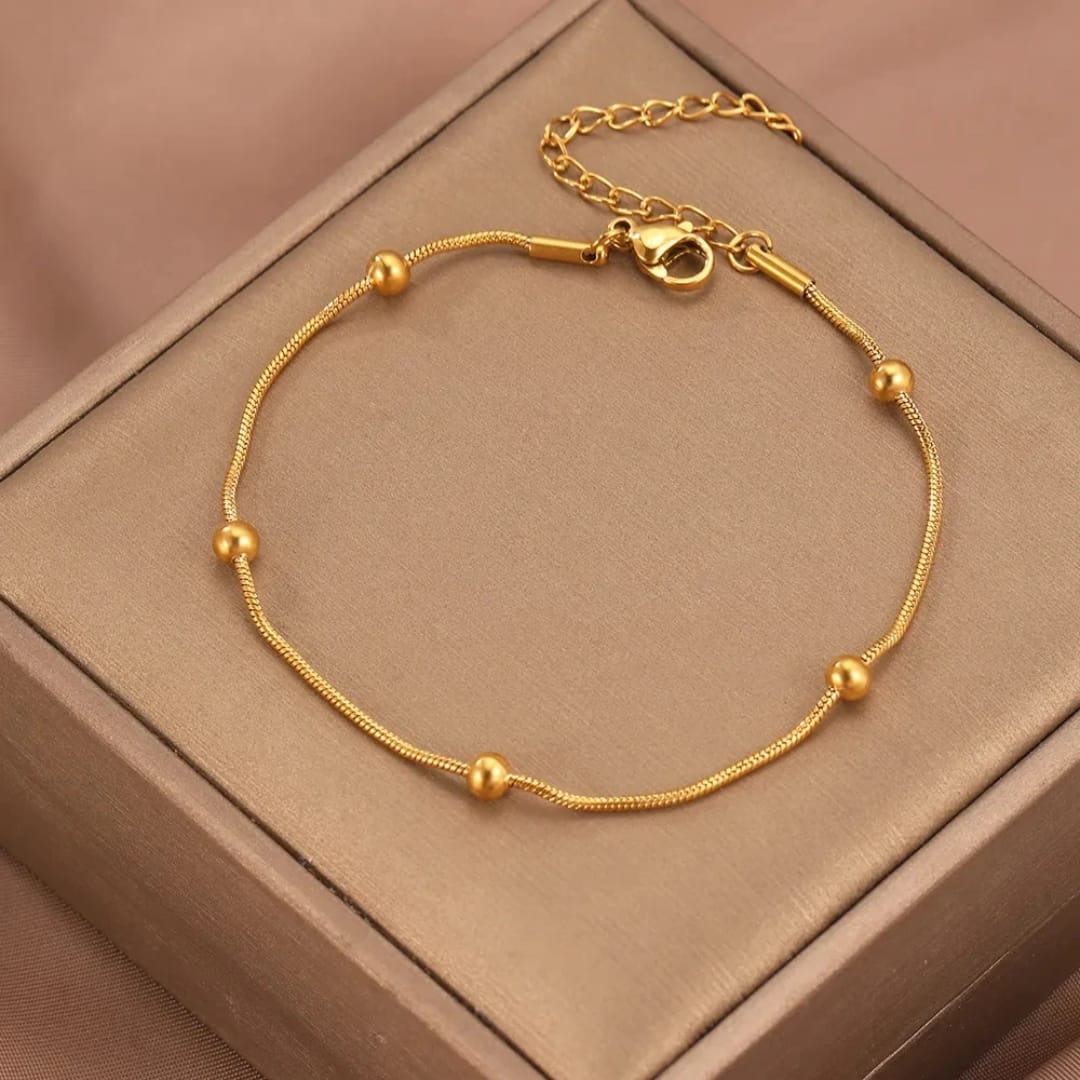 Bracciale Sottile con Sfere Dorate in Acciaio Inox
